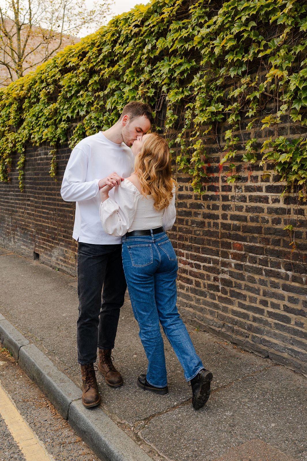 young couple kisses in the streets of london