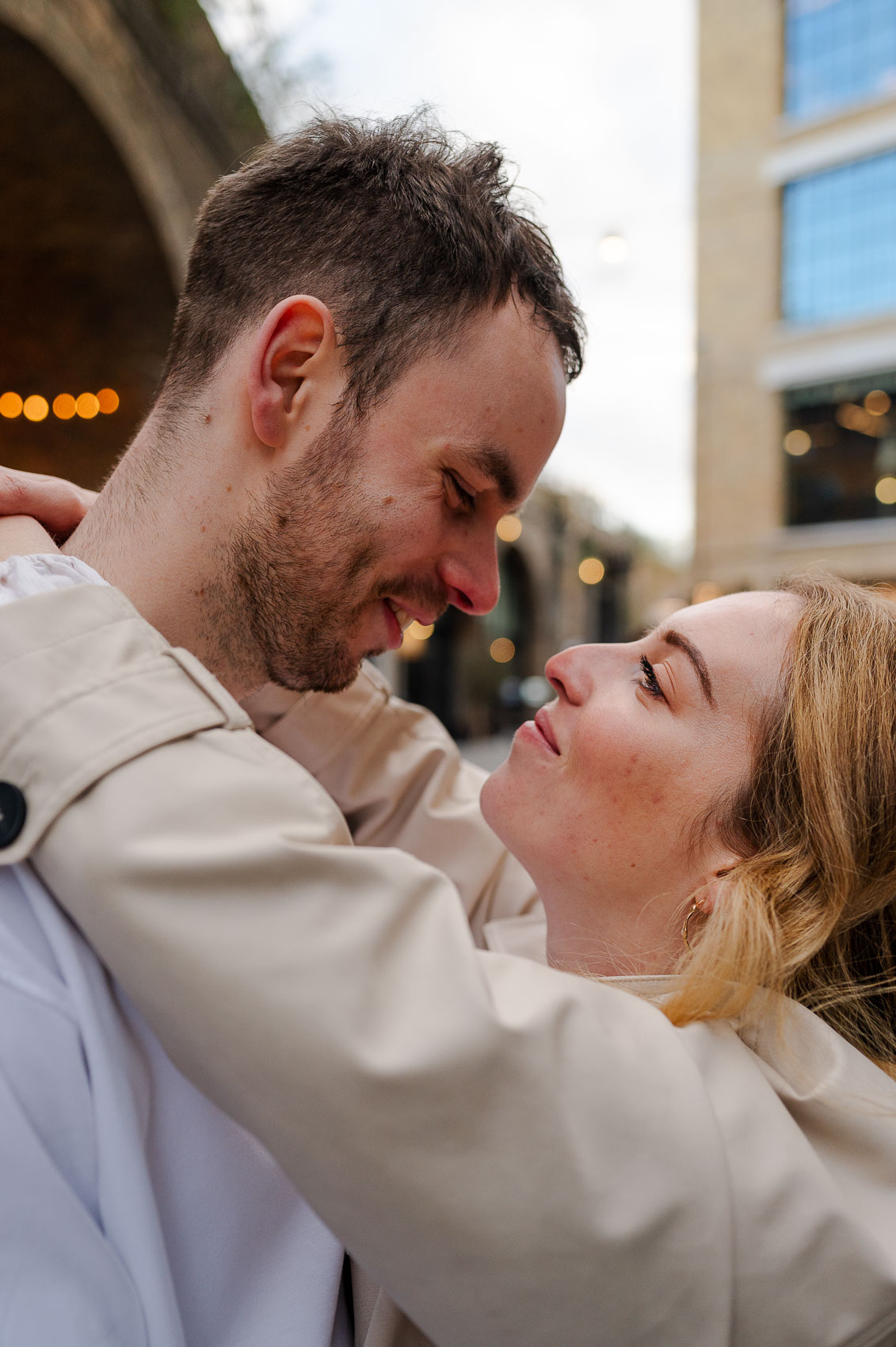 young couple embrace and smile in the streets of london