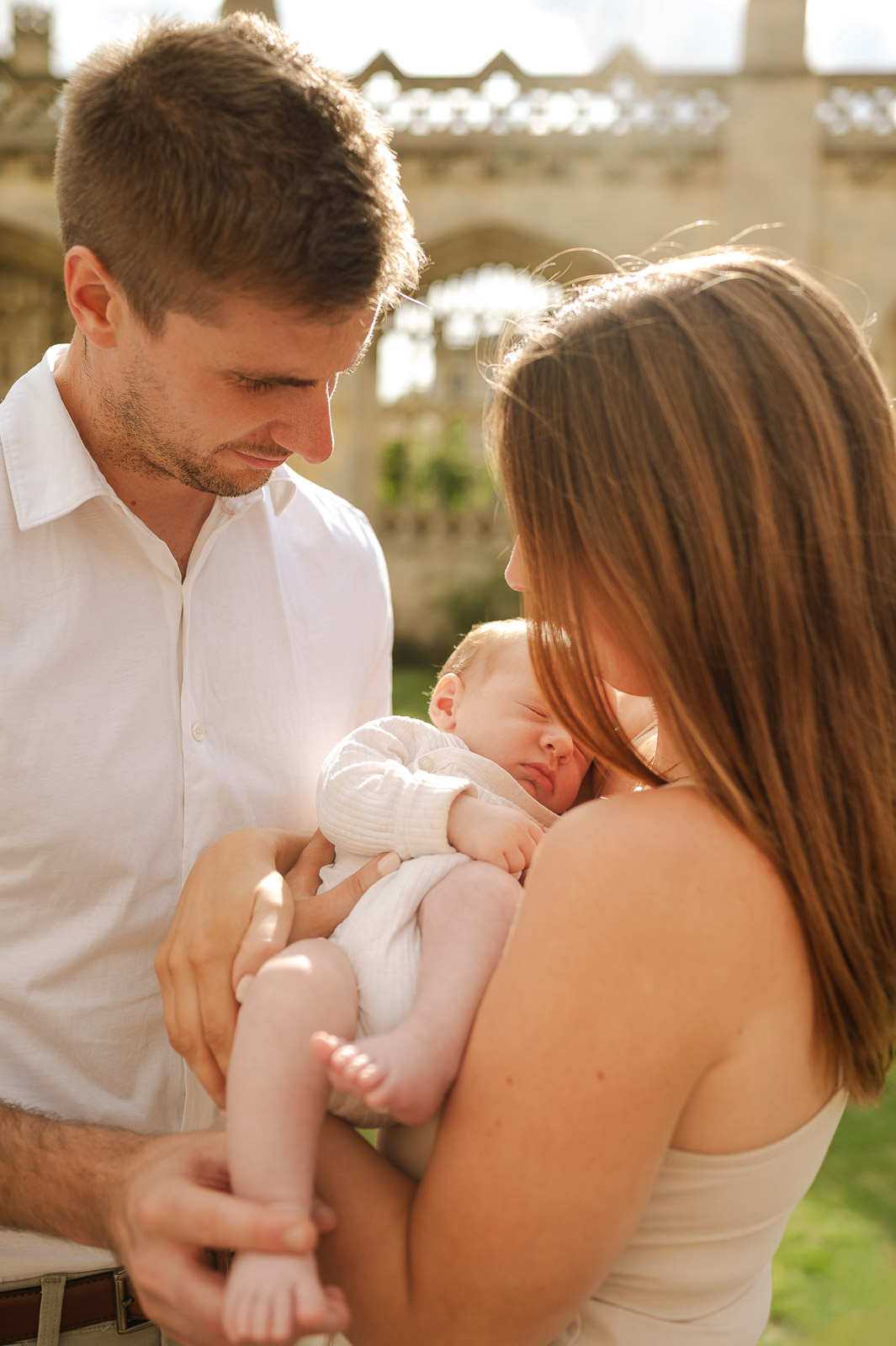 newborn baby in cambridge with his young family gently holding him